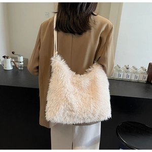 Close-up of a cream plush tote bag worn by a model in a minimalist coffee shop setting