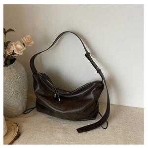 Detail of coffee brown hobo bag with soft faux leather texture and adjustable strap