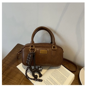 Brown vintage leather pillow bag with gold logo plate and cute black cat charm