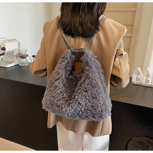 Close-up of soft grey plush backpack featuring fuzzy faux fur texture and slim leather straps