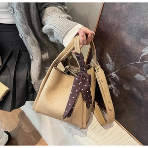 Detail of khaki lychee grain bucket bag with silk scarf handle and leather strap