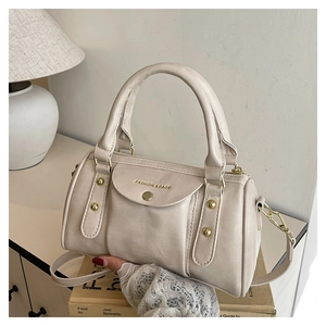 Close-up of cream Boston bag featuring gold rivets and FASHION & BAGS lettering detail