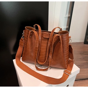 Detail of vintage brown crocodile texture tote bag with stylish wide woven strap