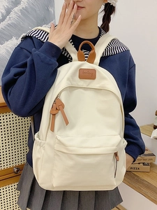 Cream canvas school backpack with leather details and large front pocket for students