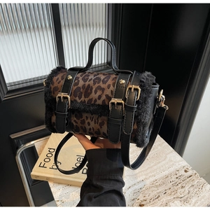 Détail du sac léopard avec bordures en peluche noire et boucles métalliques dorées