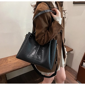 Detailed view of black crocodile pattern tote bag with adjustable shoulder strap