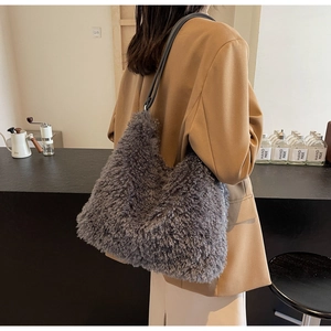 Side view of gray fuzzy plush shoulder bag with black faux leather straps in a cafe
