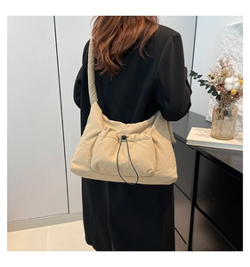 Dettaglio borsa shopper beige imbottita con tasca a coulisse e tracolla con nodo morbido