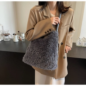 Detail view of large dark grey faux fur tote bag with long curly plush texture