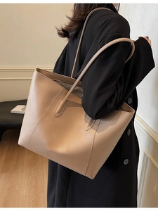 Minimalist large khaki leather tote bag for women shown from a stylish side perspective