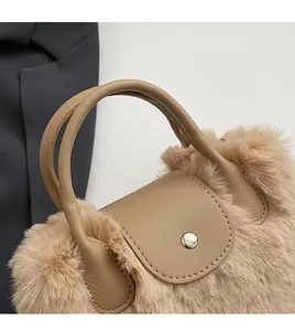 Détail de la texture en fausse fourrure avec poignée en cuir et bouton pression en argent