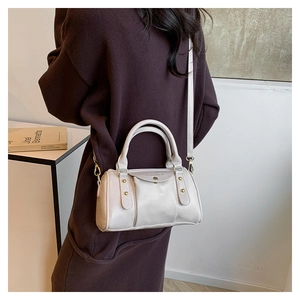 Detail of off-white Boston style handbag with metal studs and textured PU leather
