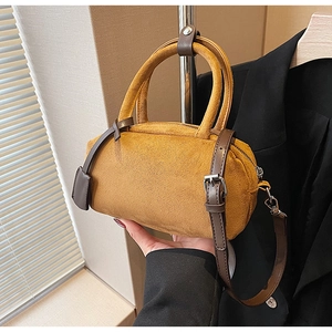 Ginger frosted boston bag with dark brown leather handles shown being held
