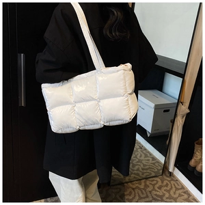 Close-up of white quilted puffer tote bag with glossy finish and square texture