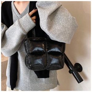 Polished black quilted tote bag shown on shoulder for daily autumn fashion style
