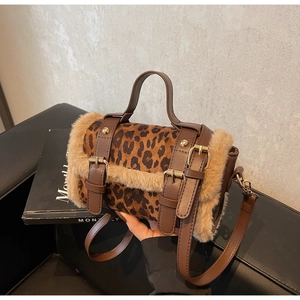 Gros plan du sac cylindre imprimé léopard avec bordure en fourrure et boucles d'or