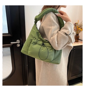 Dettaglio borsa trapuntata verde con tasca a coulisse e tracolla imbottita morbida