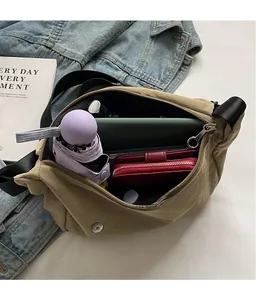 Detail view of the large capacity interior of the dark khaki crossbody bag with daily items