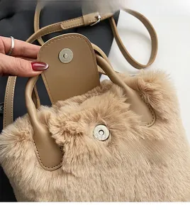 Détail d'un sac à main en peluche marron avec bouton magnétique argenté et bandoulière