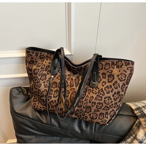 Macro shot of leopard print canvas texture and slim black shoulder straps on tote bag