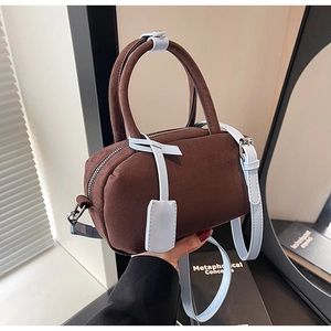 Macro detail of brown suede boston bag with light blue leather handles and silver zipper