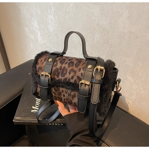 Détail du sac bandoulière léopard avec garniture en fausse fourrure noire et boucle dorée