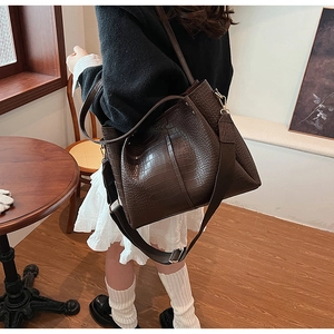 Detail of dark brown faux crocodile leather tote bag with dual shoulder strap design