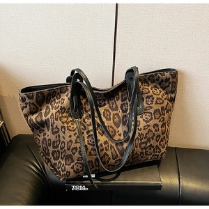 Detail of the leopard print tote bag with black leather handles and spacious interior