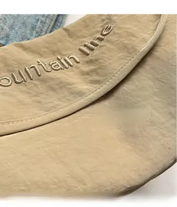 Detailed macro view of khaki canvas fabric texture with mountain line embroidery