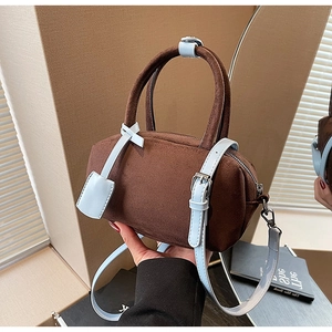 Close-up of contrast design brown suede pillow bag with light blue straps and silver buckle