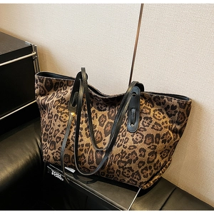 Macro detail of large leopard print tote bag with black leather shoulder straps