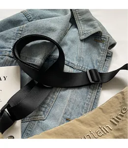 Detail of adjustable black nylon shoulder strap with buckle for versatile crossbody bags