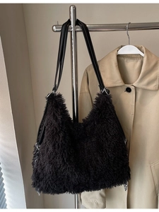 Fuzzy black faux fur tote bag with leather straps styled with a classic trench coat