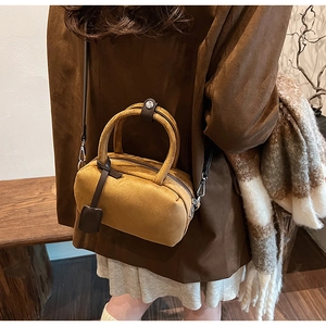 Detail of a ginger frosted suede pillow bag styled with a brown blazer for autumn