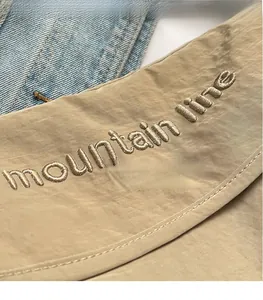 Macro view of mountain line 3D embroidery on khaki canvas fabric with denim texture