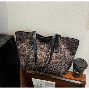 Leopard print tote bag placed on a wooden magazine rack with a coffee cup and magazine