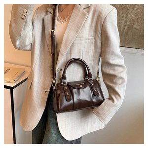 Detail of dark brown leather Boston bag with metal hardware and fashion text engraving
