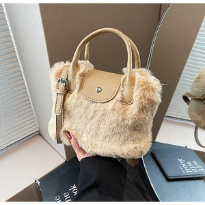Détail d'un sac à main en fausse fourrure kaki avec poignée en cuir et fermoir