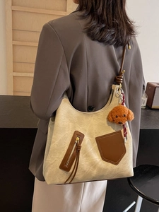 Retro canvas shoulder bag in khaki and brown leather, featuring a plush teddy charm