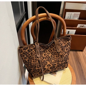 Detail of leopard print tote bag hanging on a vintage chair showing large capacity