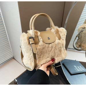 Détail d'un sac à main en peluche marron clair avec lanières en simili cuir et boucle