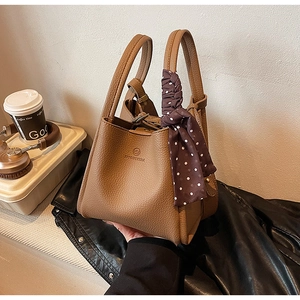 Brown litchi grain bucket bag with silk scarf detail on handle and adjustable strap