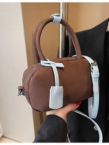 Brown suede mini pillow bag with light blue top handles and adjustable shoulder strap