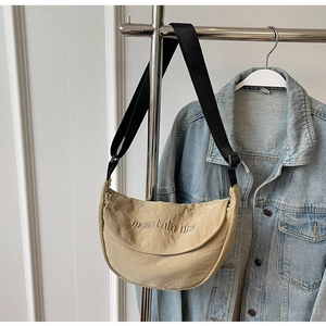 Detail of khaki crescent crossbody bag with mountain line embroidery and adjustable strap