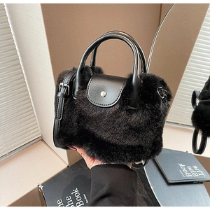 Détail de la peluche noire en fausse fourrure et du cuir mat avec boucles métalliques argentées