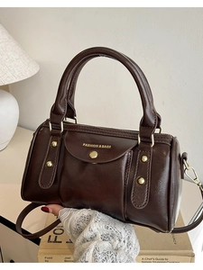 Retro dark brown cylindrical handbag with gold hardware and adjustable strap for women