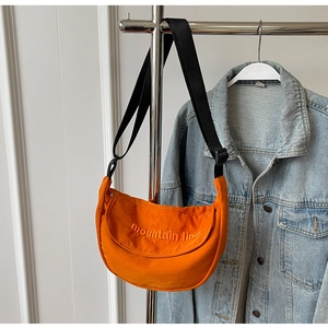 Detail of orange nylon half-moon crossbody bag with mountain line letter embroidery