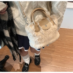 Détail de la texture en fausse fourrure beige et rabat en cuir sur le petit sac à main