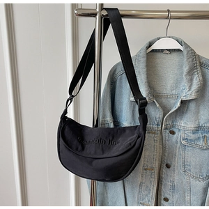 Detail shot of black nylon half-moon bag with mountain line embroidery on a hanger
