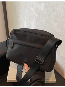 Minimalist black waterproof nylon crossbody bag with adjustable strap and zip pockets